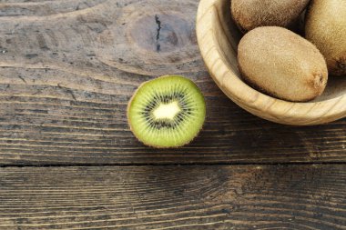 Ahşap ahşap arka plan tabağa olgun tüm kivi. tex için alan