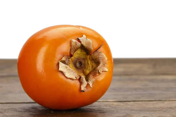 木製の背景に丸ごと完熟柿は 健康の秋果実 — ストック写真