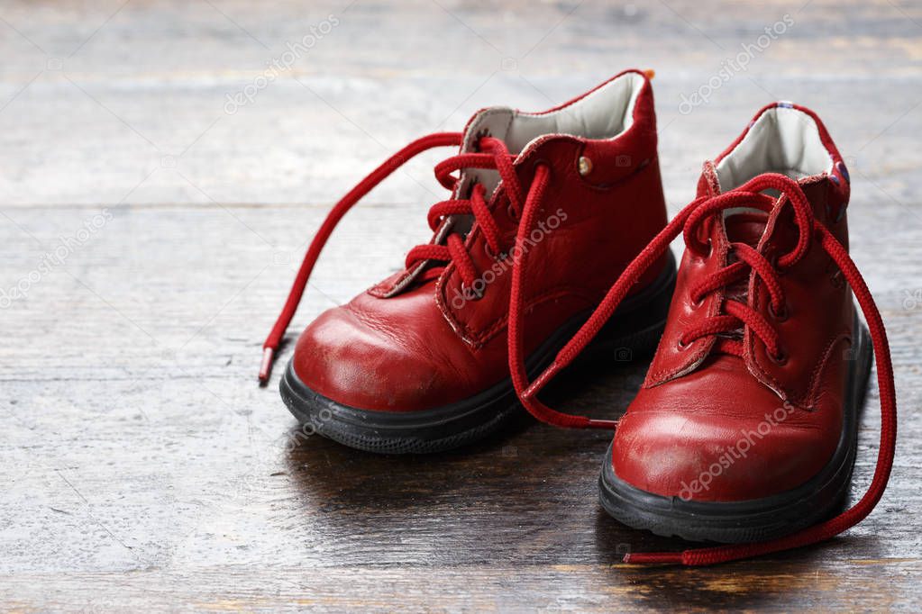 worn baby red leather shoes. small autumn baby shoe