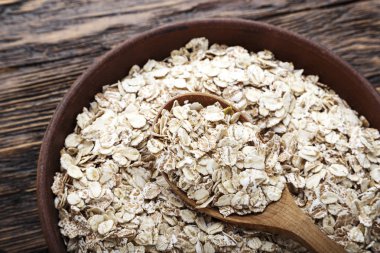 Ahşap arka plan bir kil tabağa çiğ yulaf gevreği. Sağlıklı karbonhidrat kahvaltı. tex için alan