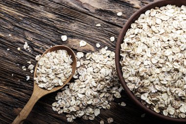 Ahşap arka plan bir kil tabağa çiğ yulaf gevreği. Sağlıklı karbonhidrat kahvaltı. tex için alan