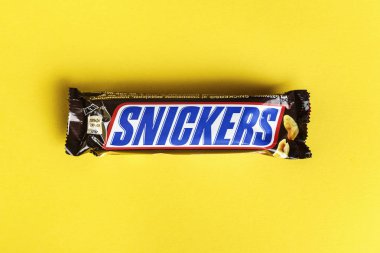 Ukrayna, Kiev 29 Mart 2018. Çikolata Snickers sarı bir arka plan üzerinde. Snickers barlar Mars Incorporated tarafından üretilmektedir.