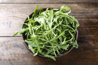 taze roka ahşap bir masa üzerinde bir tabak içinde. tex için alan