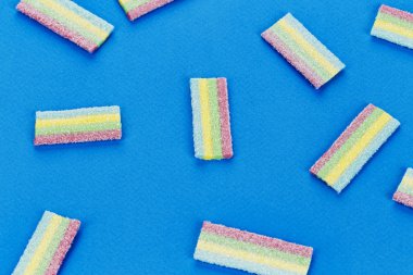 Çok renkli jöle tatlı şeker mavi bir arka plan üzerinde bir sürü. tex için alan