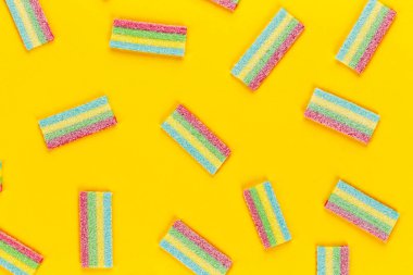 Çok renkli jöle tatlı şekerler sarı bir arka plan üzerinde bir sürü. tex için alan