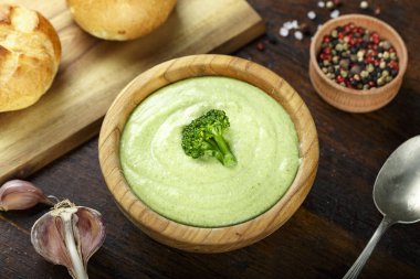 Kremalı brokoli çorbası bir plaka üzerinde koyu ahşap arka plan. bir tas çorba yanında taze ekmeği vardır. top vie