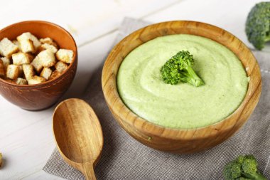 Kremalı brokoli çorbası bir plaka üzerinde koyu ahşap arka plan. kase çorba yanında ekmek kırıntıları plakadır. top vie