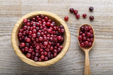 Taze kızılcık bir tabak ve kaşık ahşap bir masa üzerinde. tex için alan