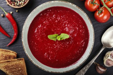 masaya bir tabak içinde gaspaço domates çorbası. Yakınlarda kruton ve baharat bulunmaktadır. tex için alan