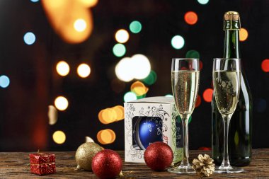 bir cam ve yılbaşı böke arka planda bir şişe şampanya