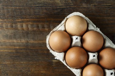 bir kağıt tepsisi ahşap arka plan üzerinde tavuk yumurtası. tex için alan