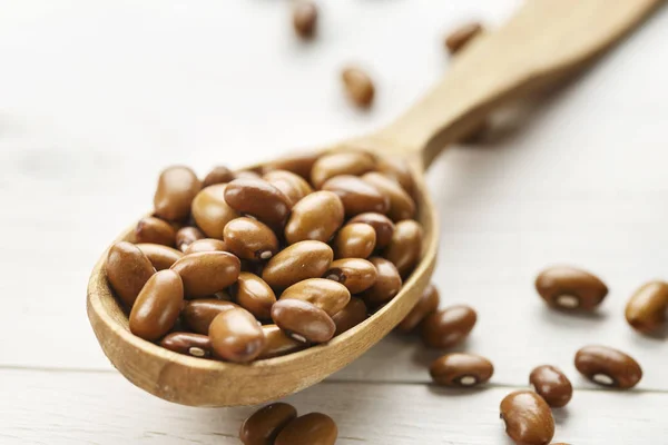 Bruin Rauwe Bonen Een Houten Lepel Een Houten Pagina — Stockfoto