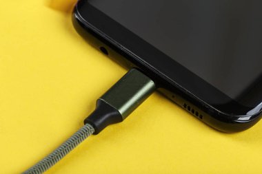 belgili tanımlık smartphone üzerinde sarı bir adam bir pembe güç bankadan şarj