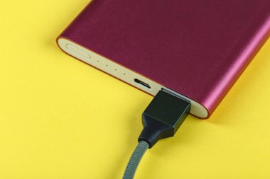 belgili tanımlık smartphone üzerinde sarı bir adam bir pembe güç bankadan şarj