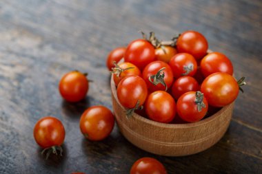 ahşap arka plan üzerinde bir tabak içinde küçük kiraz domates. tex için alan