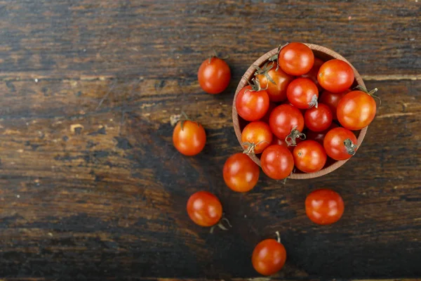 ahşap arka plan üzerinde bir tabak içinde küçük kiraz domates. tex için alan