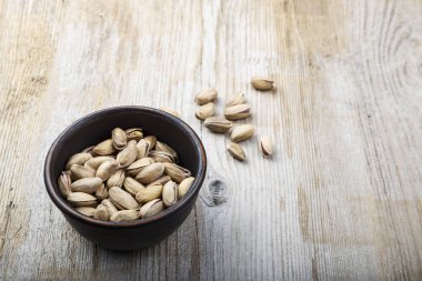 ahşap arka plan üzerinde bir tabak içinde fıstık. metin için yer. geleneksel bira veya şarap snac