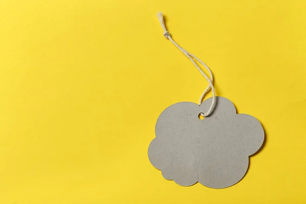 Designer label in the shape of a cloud without an inscription on a yellow background. space for tex