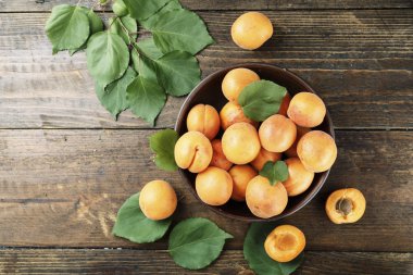 Ahşap arka plan üzerinde bir kil plaka yapraklarla olgun kayısı. tex için alan