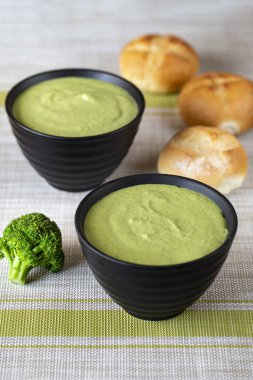 Kremalı brokoli çorbası bir plaka üzerinde koyu ahşap arka plan. bir tas çorba yanında taze ekmeği vardır. top vie