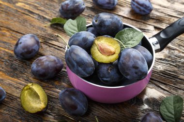 eski püskü ahşap arka plan üzerinde bir tencerede olgunlaşmış erik. tex için alan