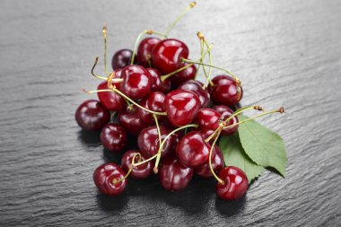 Olgun kırmızı tatlı kiraz bir siyah arka plan üzerinde dağınık vardır. tex için alan