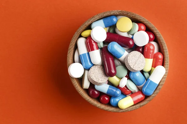 different colored pills in a plate on a bright background. place for text. drug treatmen