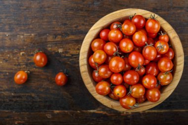 ahşap arka plan üzerinde bir tabak içinde küçük kiraz domates. tex için alan