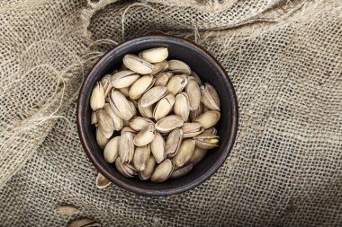 çuval bezi arka plan üzerine bir tabak içinde fıstık. metin için yer. geleneksel bira veya şarap snac