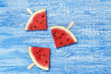 Üçgen dilimler karpuz bir sopa üzerinde eski püskü bir mavi adam