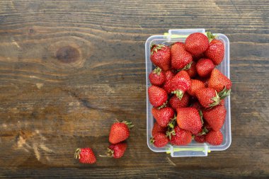 masanın üzerinde bir plastik kap içinde çilek. tex için alan