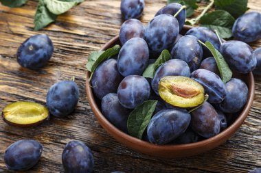 Olgun erik plaka üzerinde koyu kahverengi ahşap bir masa. rustik tarzı.