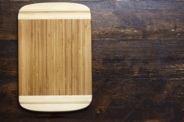 Dikdörtgen planlı ahşap kesme tahtası ahşap bir masa üzerinde. tex için alan