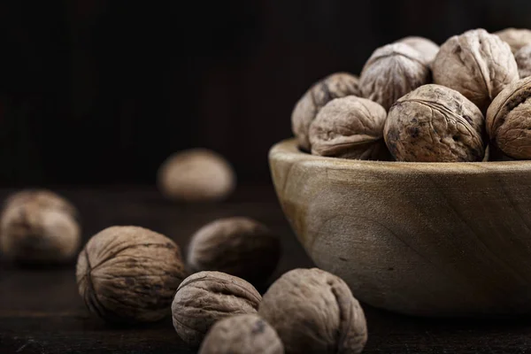 Inshell whole walnuts on dark wooden background. in a wooden plat — Stock Image Inshell Whole Walnuts Dark Wooden Background Wooden Plat Royalty Free Stock Images