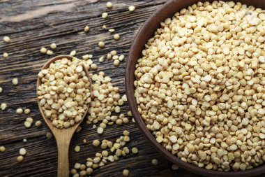 Kahverengi ahşap bir masa bir tabağa ham kuru bezelye. tex için alan