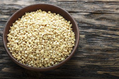 Kahverengi ahşap bir masa bir tabağa ham kuru bezelye. tex için alan