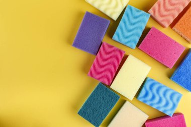 Çok çok renkli sünger sarı bir arka plan üzerinde bulaşık için. tex için alan