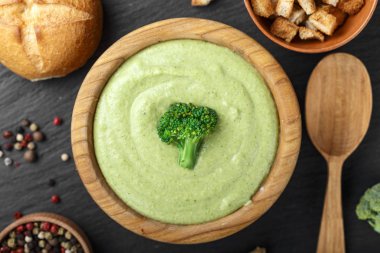 siyah bir masada yemek brokoli çorbası. Yakınlarda ekmeği ve baharat bulunmaktadır