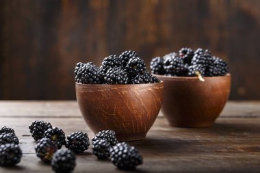 bir ahşap arka plan ve scattere kil tabağa böğürtlen