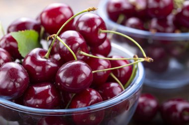 tatlı kırmızı kiraz ahşap arka plan üzerinde bir tabak içinde.