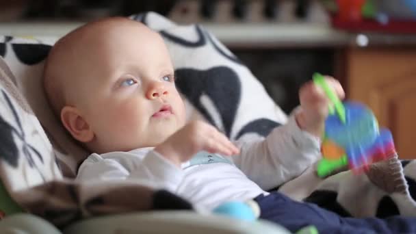 Baby Boy op kinderstoel met speelgoed — Stockvideo
