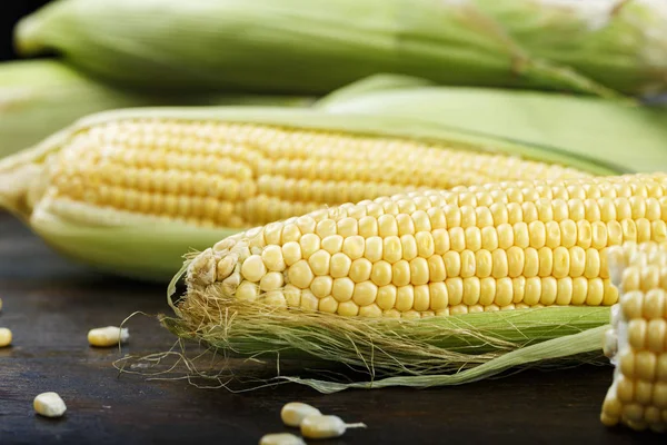 Young corn on wooden background — Stock Photo, Image