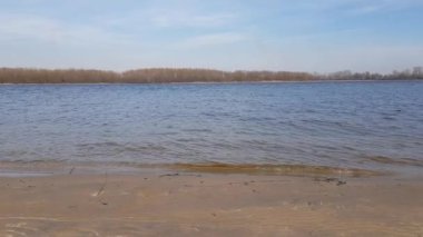 kumlu kıyıya yakın bir nehrin sakin dalgalar