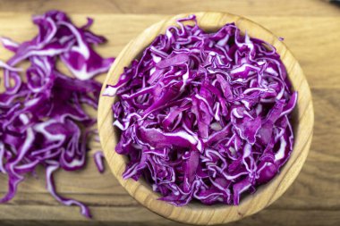 Kırmızı lahana ince doğranmış ahşap bir tabakta. 