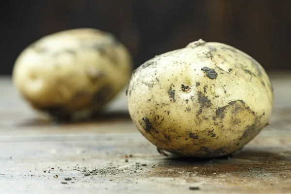 Surowe ziemniaki na rustykalnym drewnianym tle — Zdjęcie stockowe