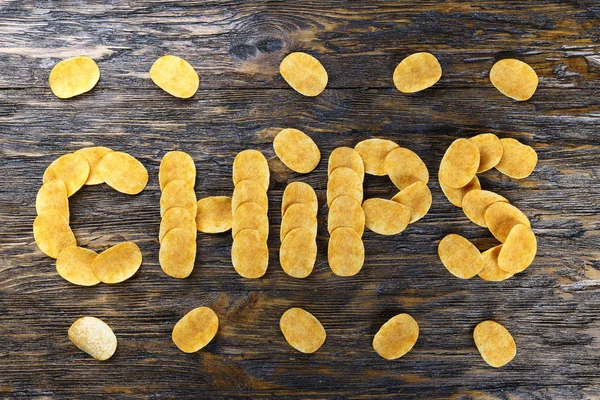 Potatischips på träbord. — Stockfoto