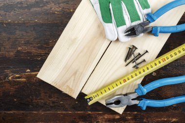 Evde çalışmak ve ahşap bir backgr üzerinde onarım için çeşitli araçlar