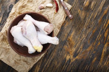 Çiğ pişmemiş tavuk bacakları, ahşap tahta üzerinde baget