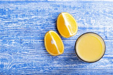 Yakın bir bardak portakal suyu dilimlenmiş portakallar yatıyordu. Görünümü