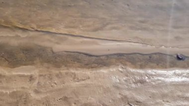 kumlu kıyıya yakın şeffaf bir nehrin sakin dalgalar.